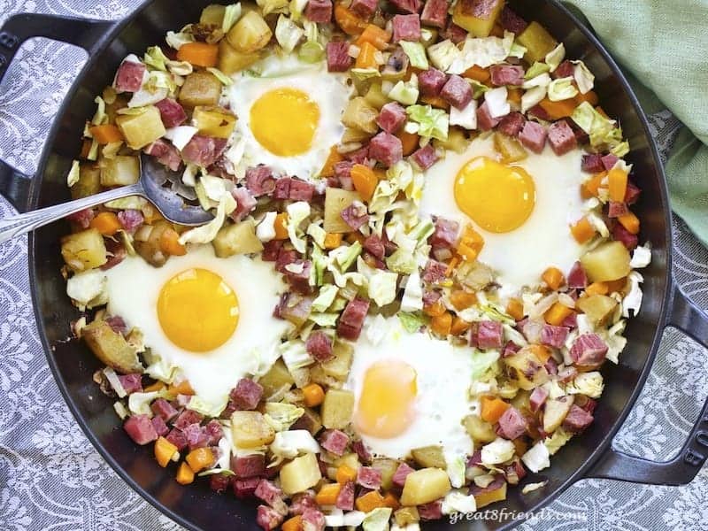 Overhead shot of corned beef hash with eggs in a cast iron skillet.