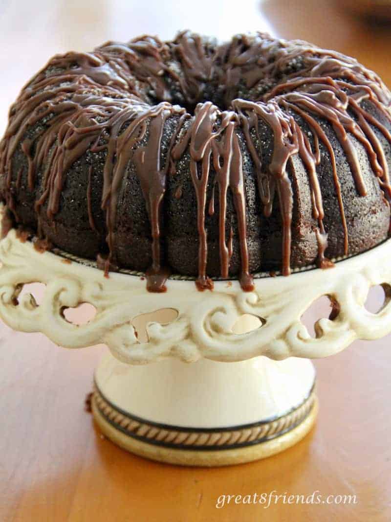 Frosted Chocolate cake on a cake stand.
