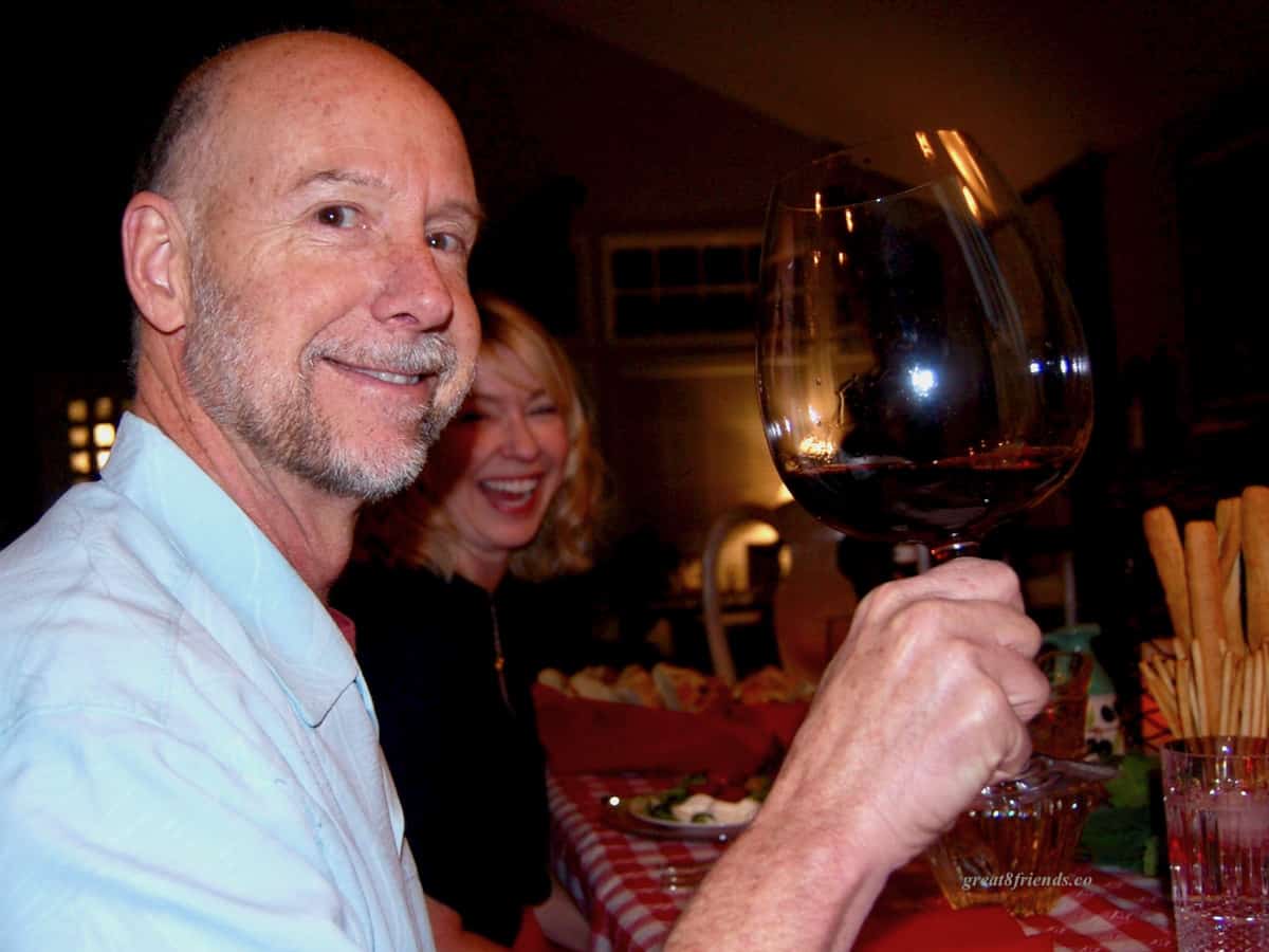 Phil holding a large glass of red wine.