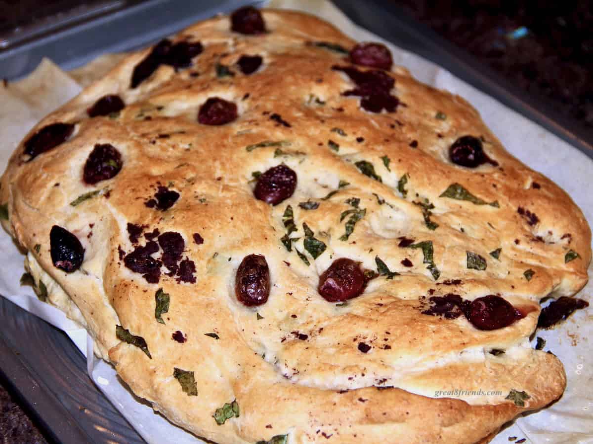 A rustic loaf of olive studded focaccia bread.