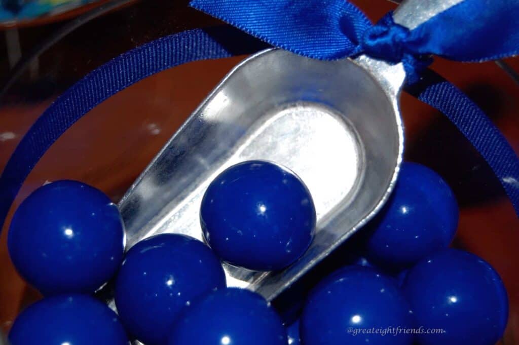 Metal scoop with blue gumballs.