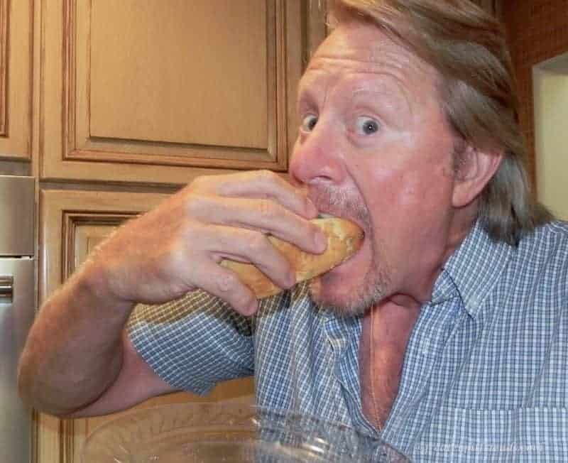 A man putting a hot dog in his mouth.