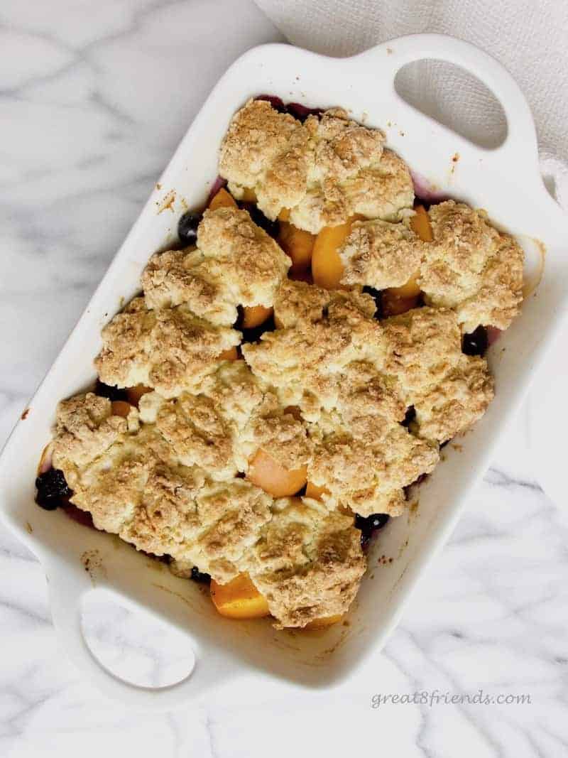 Overhead shot of Apricot Blueberry Cobbler in a white rectangular dish with handles.