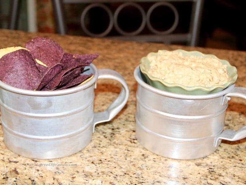 A dip and chips each served in tin cups.