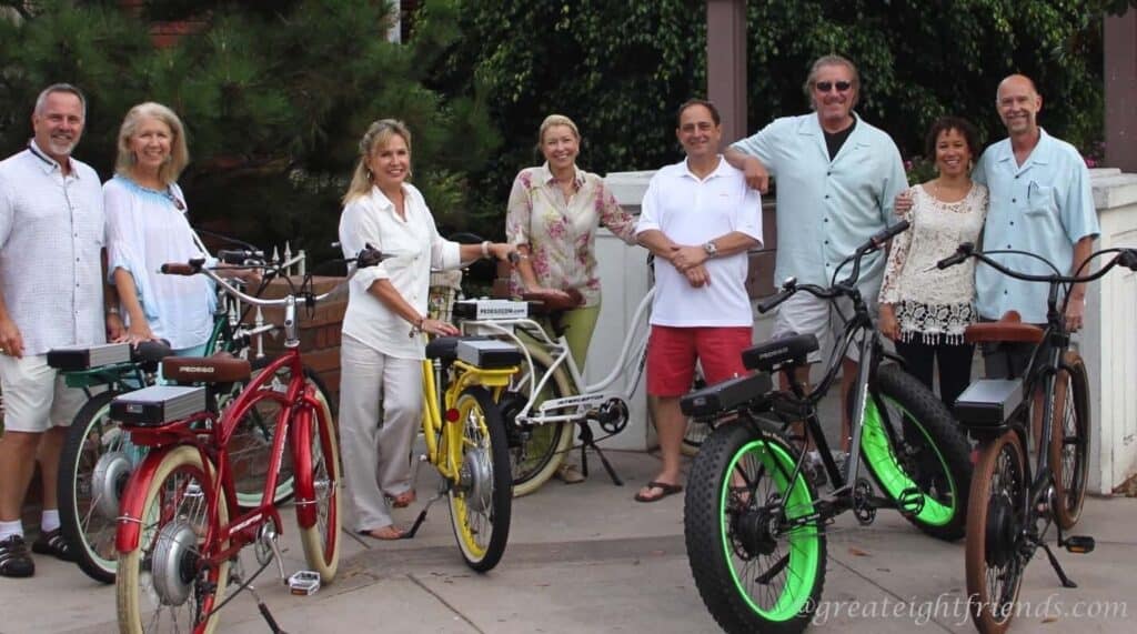 Eight people posing for photo with their bikes.