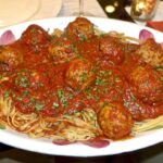 Square photo of spaghetti and meatballs.