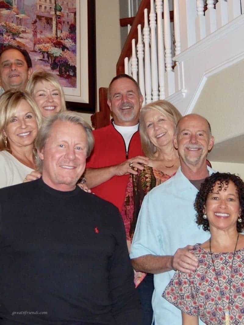 Eight people standing on a staircase smiling for the camera.