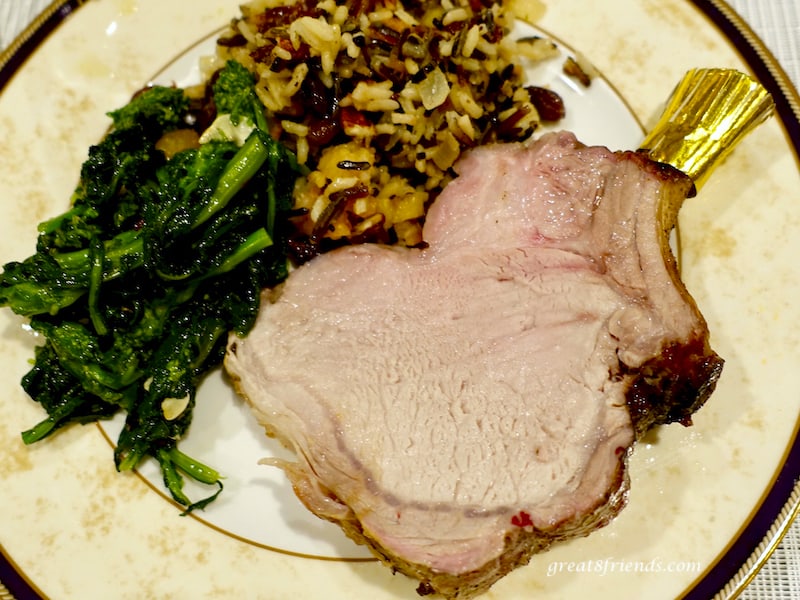 Overhead shot of slice of Crown Roast of Pork with vegetable and wild rice.