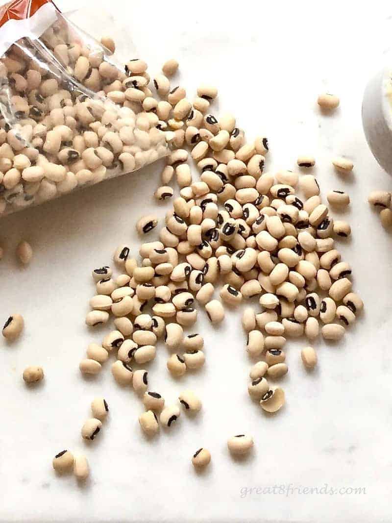 Uncooked Black-Eyed Peas spilling out of a plastic bag.