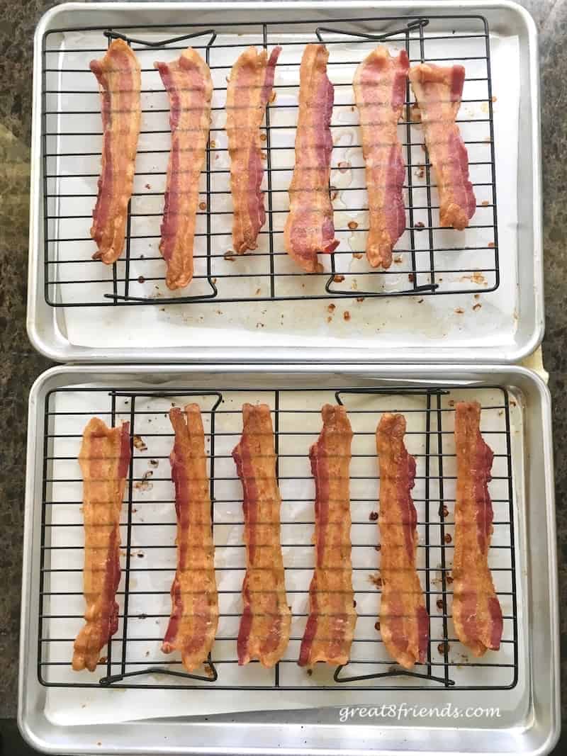 Slices of cooked bacon on baking sheet racks.