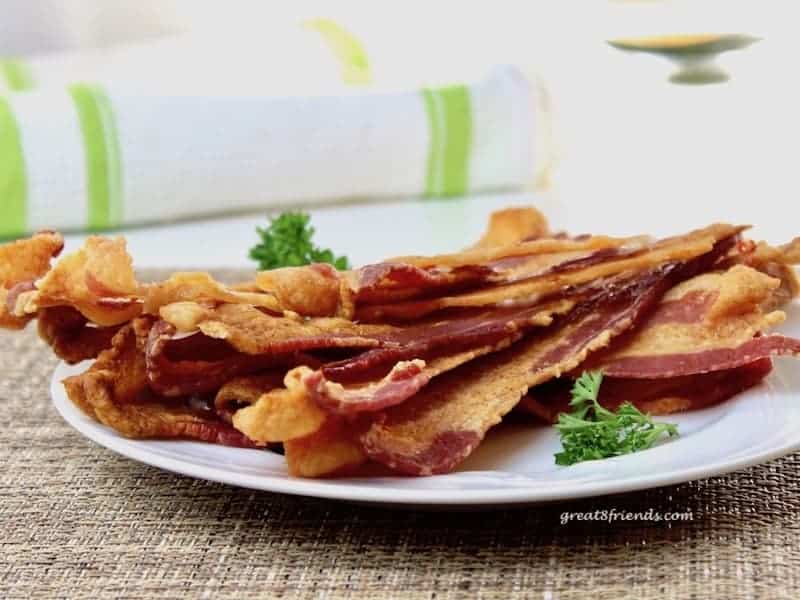 Several slices of bacon on a plate.