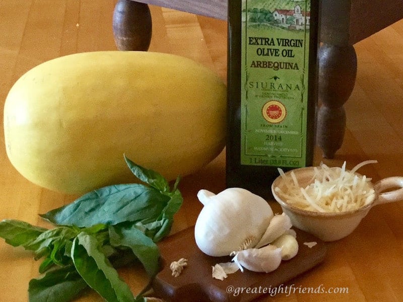 Whole spaghetti squash, garlic head, basil and olive oil.