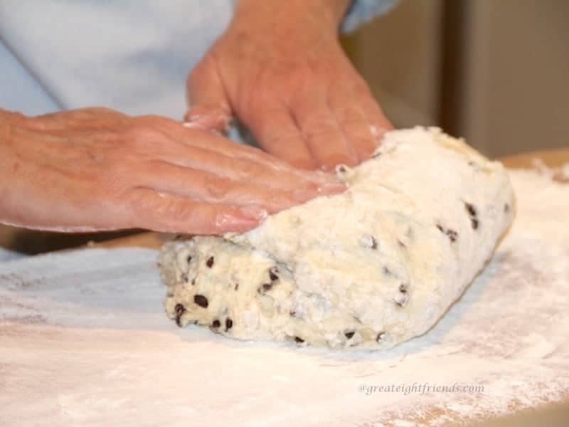 Two hands kneading bread dough.