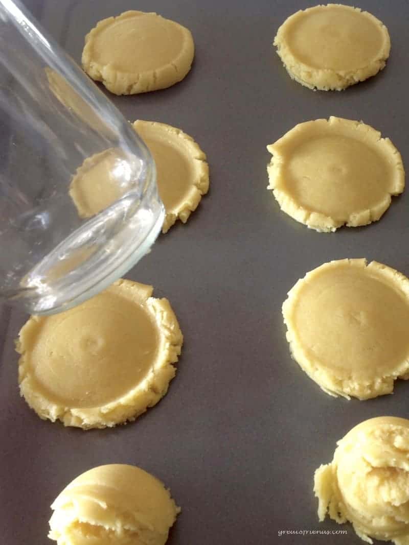 Cookie dough flattened on a baking sheet.