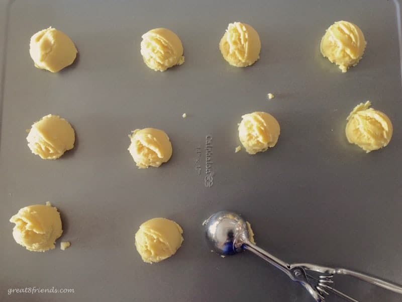 Cookie dough balls on a baking sheet.