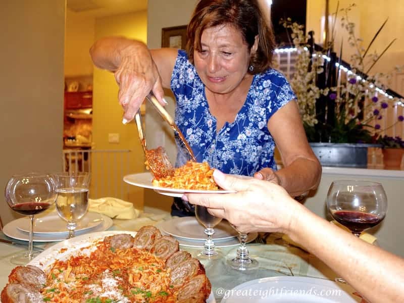 Nonna Anna filling a plate with food.