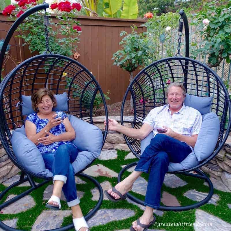 Nonna Anna and Tim relaxing in barrel chairs in the yard.