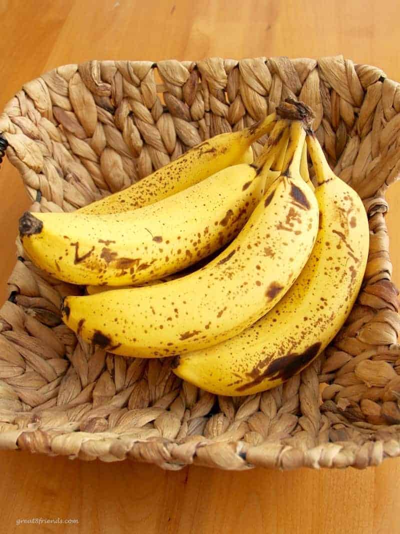 Over ripe bunch of bananas in a wicker basket.