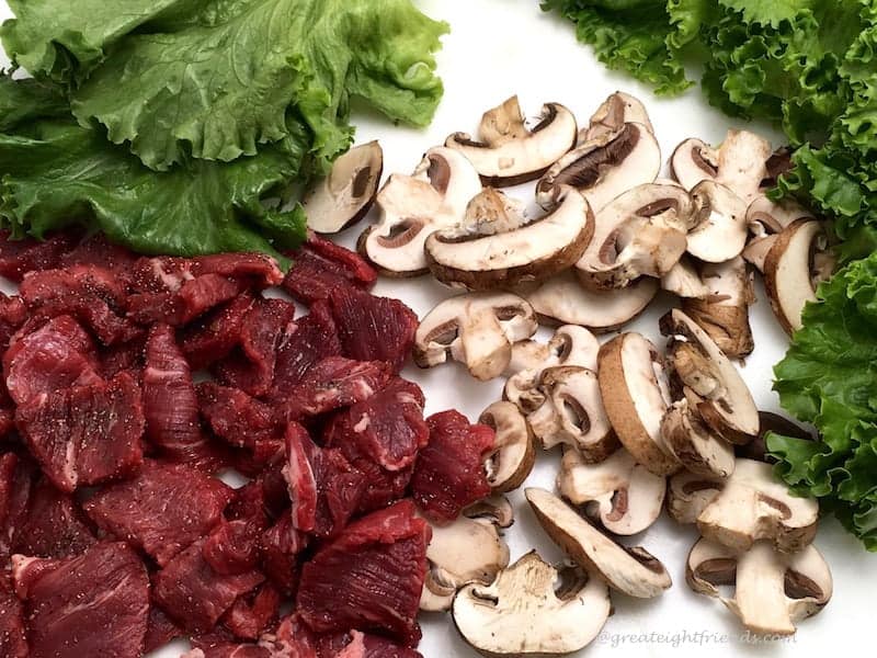 Pieces of raw beef and sliced mushrooms.