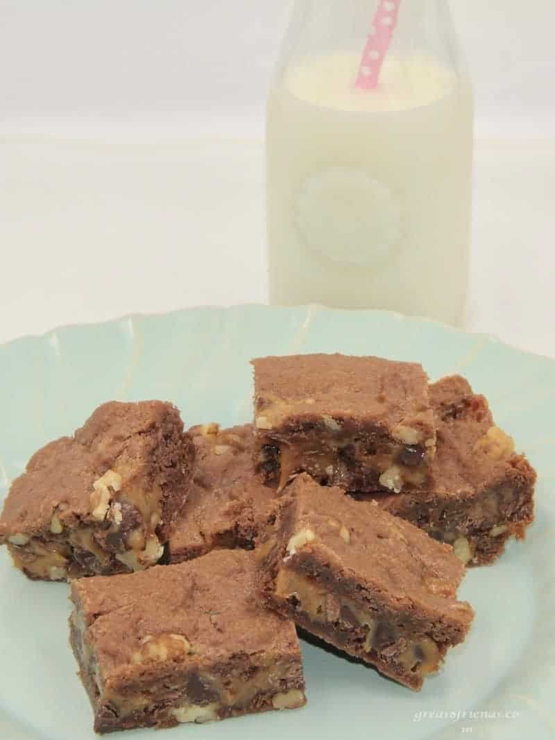 Six cut chocolate brownies made with caramel on a light green plate