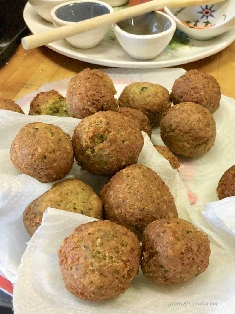 Several fried falafels draining on paper towels.