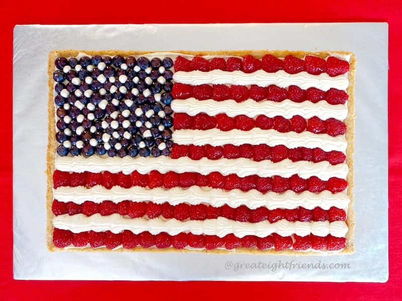 Overhead shot of a tart decorated with berries and cream to look like an American flag.