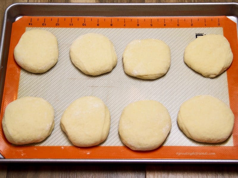 Unbaked buns on baking sheet rising