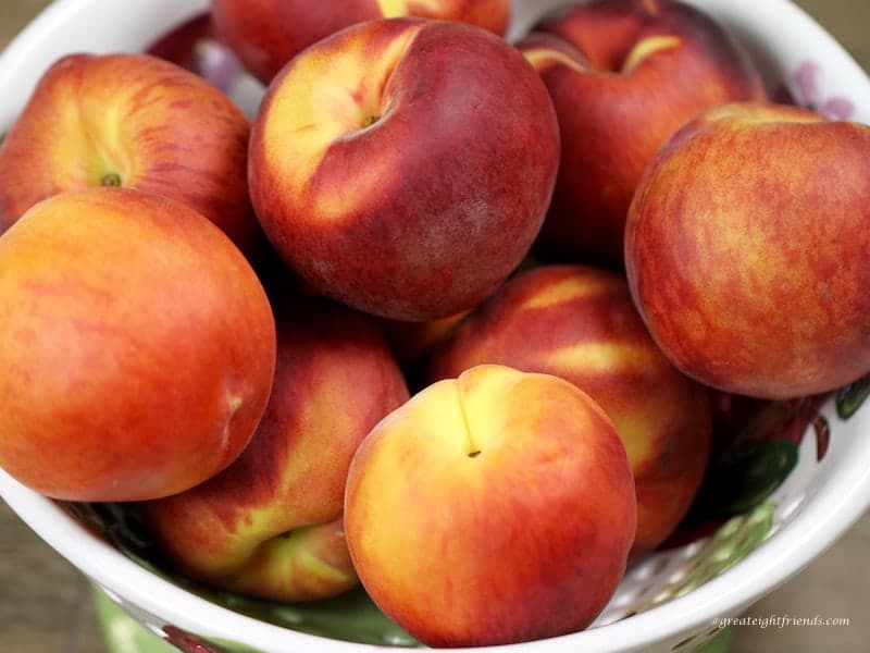 Bowl of fresh whole peaches.