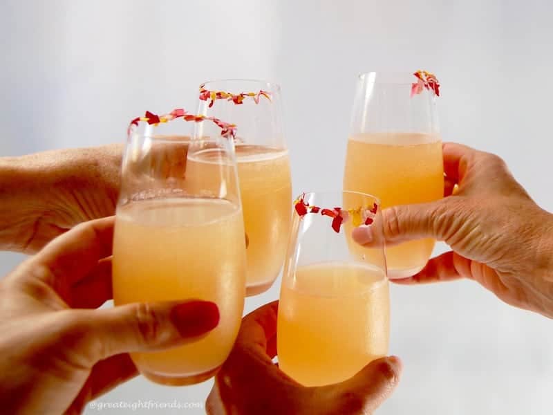 Four Pink Lemonade Margaritas in stemless flutes toasting.