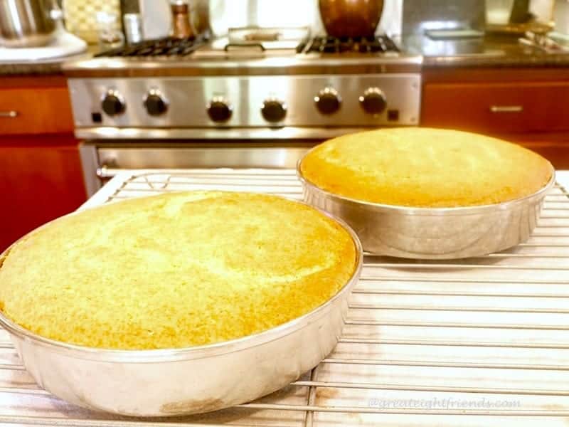 Yellow cake layers cooling on rack.