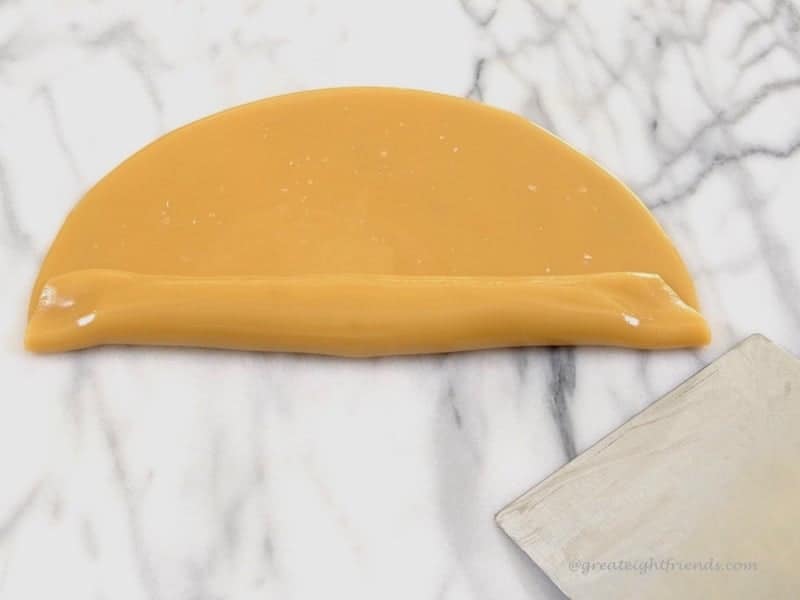 Creamy Caramels being made. Candy flat on marble board.