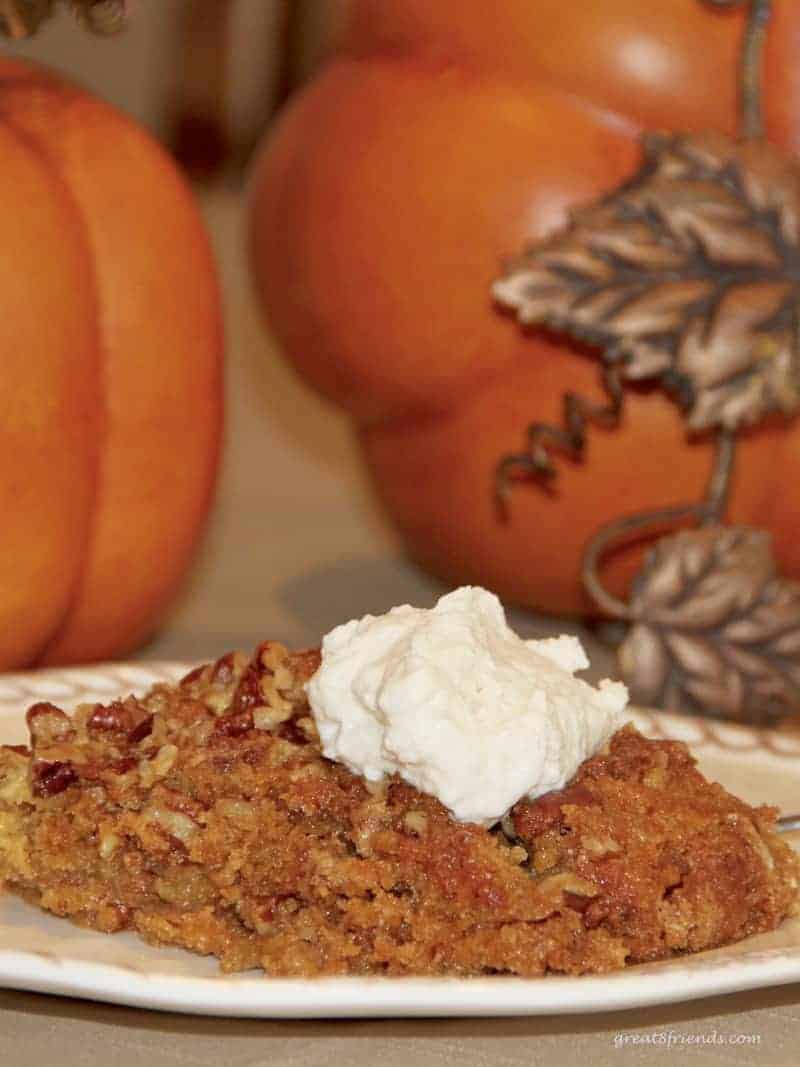 A piece of Pumpkin Pie Crunch Dessert with a dollop of whipped cream.