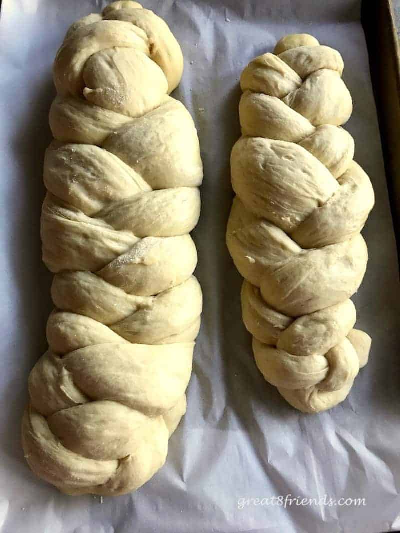 Two loaves of braided challah ready to be baked.