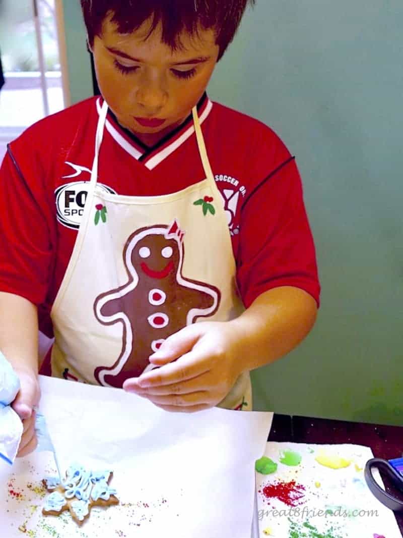 A child decorating a snowflake cookie.