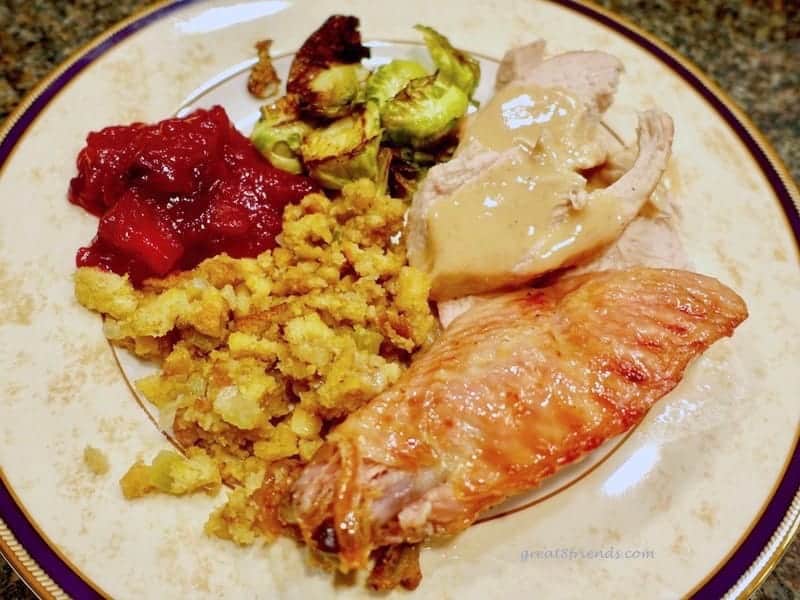 A plate of turkey, stuffing, cranberries.