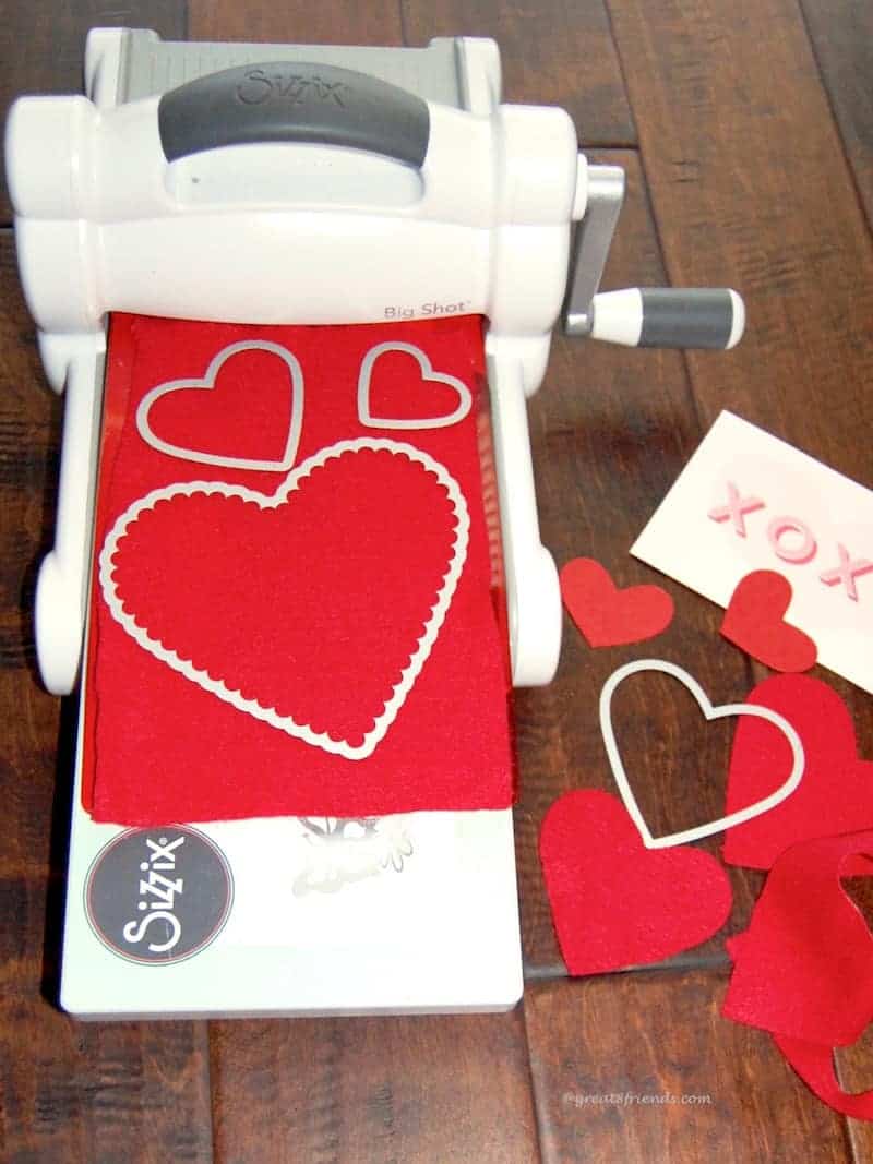 Big Shot machine cutting out hearts from red paper.