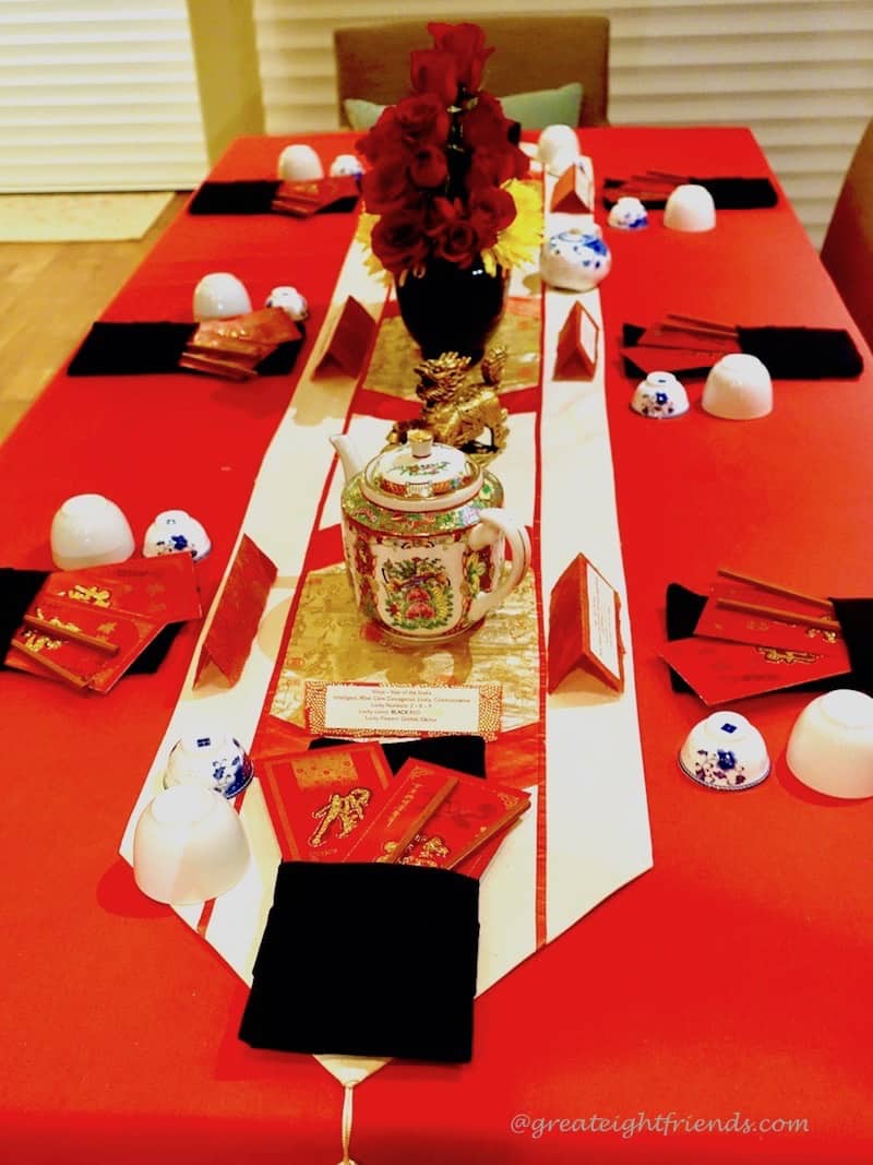 Chinese New Year Table setting with Chinese porcelain tea pot and red rose centerpiece.