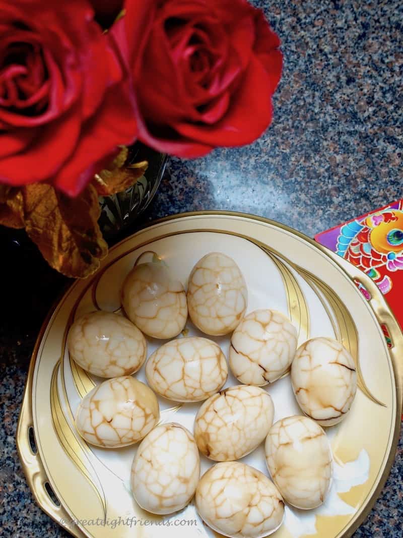 Chinese tea eggs on a gold and white plate.