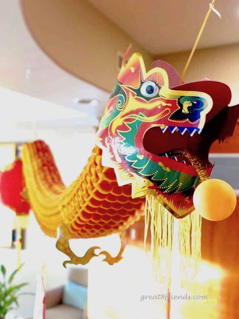 A colorful paper Chinese dragon hanging from a ceiling.