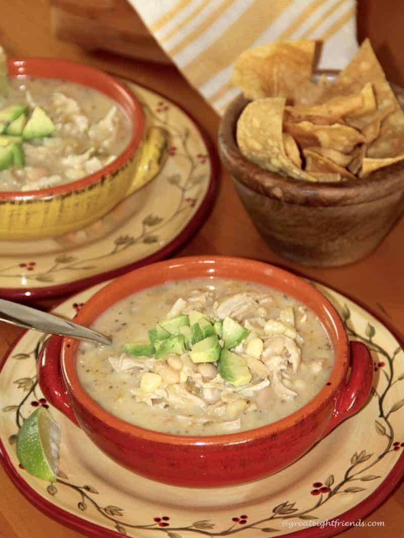 Two bowls of White Cheddar Chicken Chili and a bowl of tortilla chips.