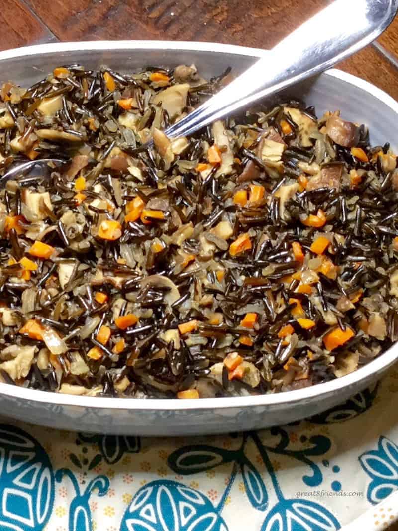 A large bowl and serving spoon of Wild Rice with Mushrooms. 