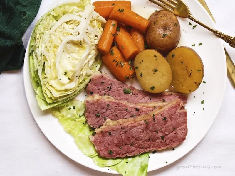 Overhead picture of corned beef dinner including cabbage, carrots and potatoes.