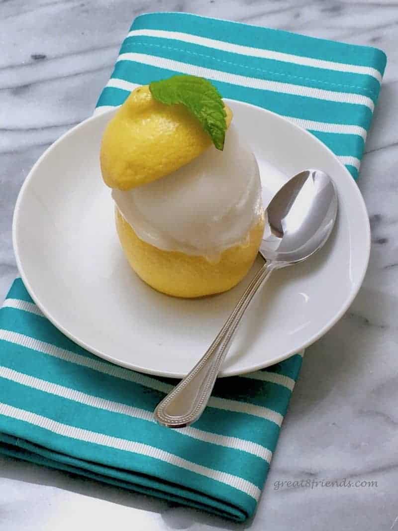 Lemon Sorbet in a Lemon Cup on a striped napkin.