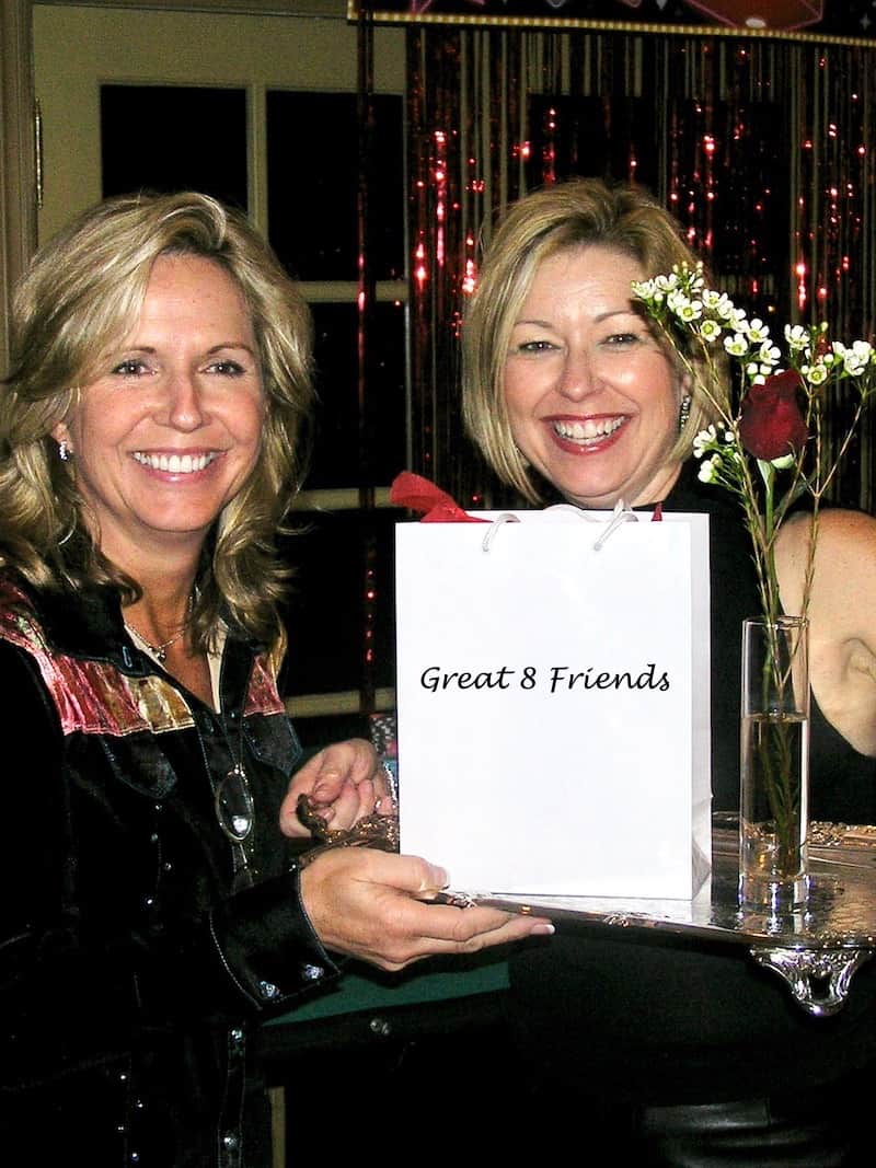 Two ladies, one holding a small white shopping bag.