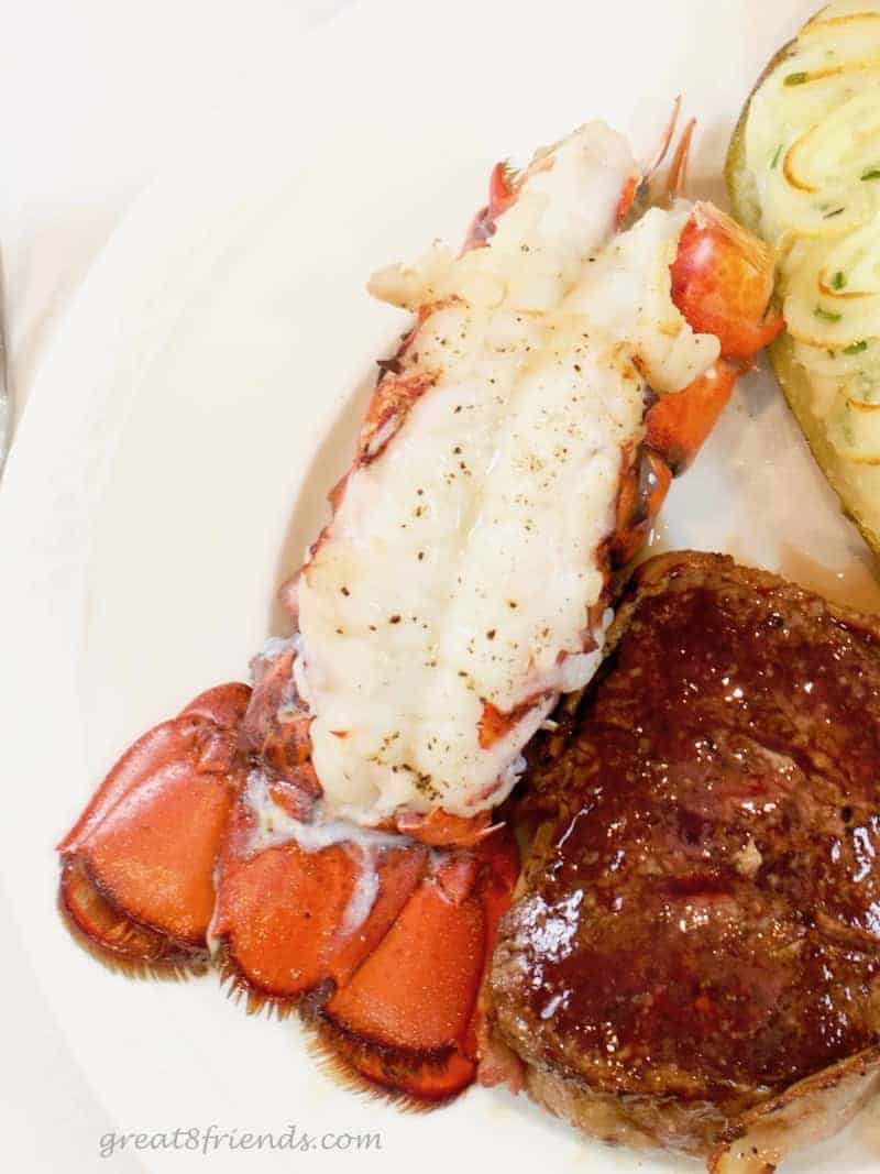 Overhead shot of a lobster tail on a white plate.