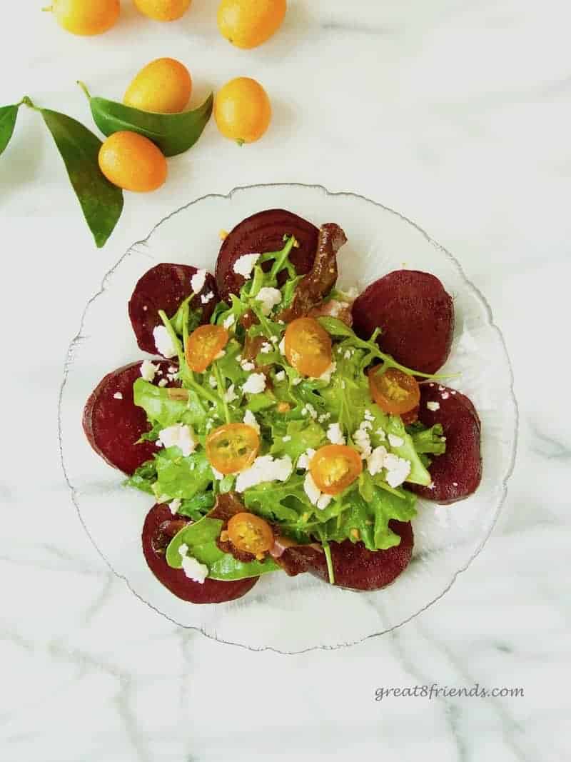 Overhead shot of Roasted Baby Beet Salad with Candied Kumquat on a glass plate.