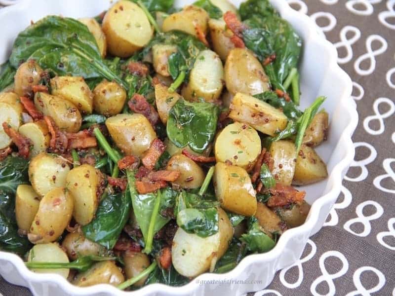 Warm Spinach Potato Salad with Bacon Vinaigrette on a brown Great 8 napkin.