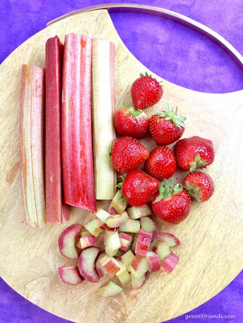 Strawberries and Fresh Rhubarb on a cutting board.