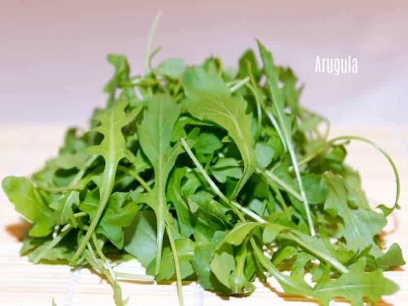 A pile of fresh arugula leaves.