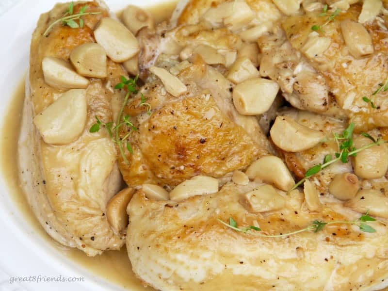 Upclose photo of chicken with whole garlic.